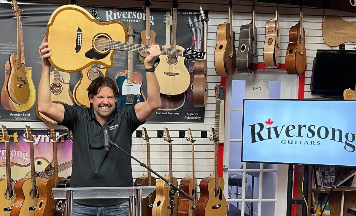 Mike Miltimore, owner of Riversong Guitars in Kamloops, B.C., is shown in this handout image, celebrating the company's P2P River Pacific guitar being named acoustic guitar of the year. It is the first time a Canadian company has won the prestigious international Musical Merchandise Review Dealers' Choice Award. (The Canadian Press/HO-Riversong Guitars)