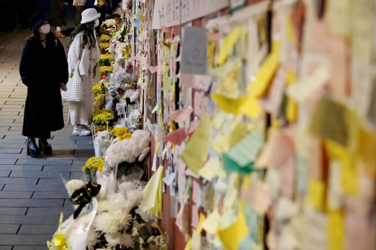 Women mourn at the scene of a crowd crush that happened during Halloween festivities, in Seoul, South Korea, on Nov. 29, 2022. (Heo Ran/Reuters)