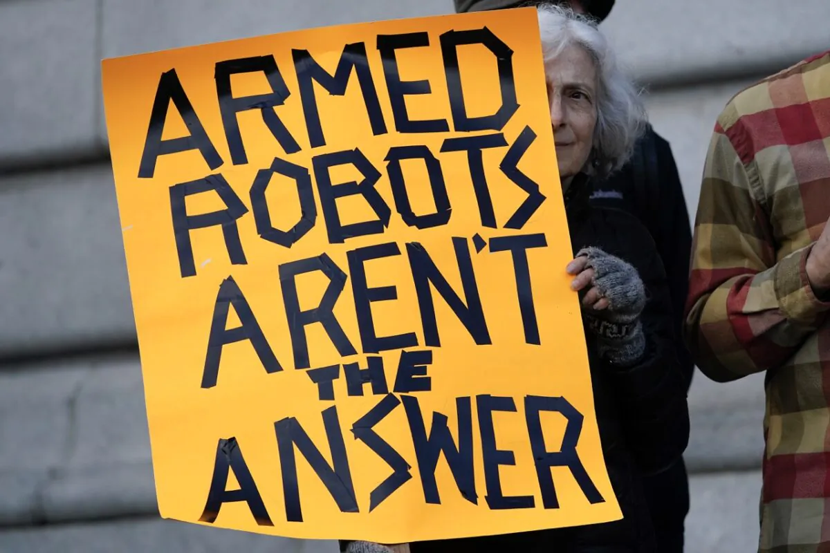 Diana Scott holds up a sign while taking part in a demonstration about the use of robots by the San Francisco Police Department outside of City Hall in San Francisco, on Dec. 5, 2022. (Jeff Chiu/AP Photo)