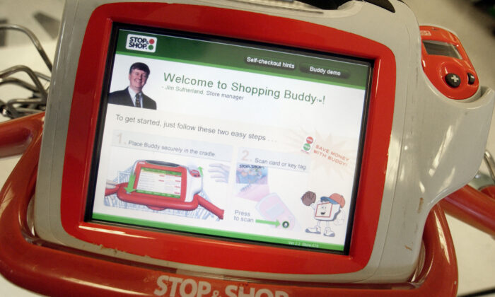 2004 年 7 月 21 日，在马萨诸塞州布伦特里的一家 Stop & Shop，可以看到触摸屏“购物伙伴”。购物伙伴是一种无线触摸屏设备，连接到购物车，可以扫描商品、给出价格、显示打折商品，甚至向客户提供他们的个人购物历史记录。  （达伦·麦科莱斯特/盖蒂图片社摄）
