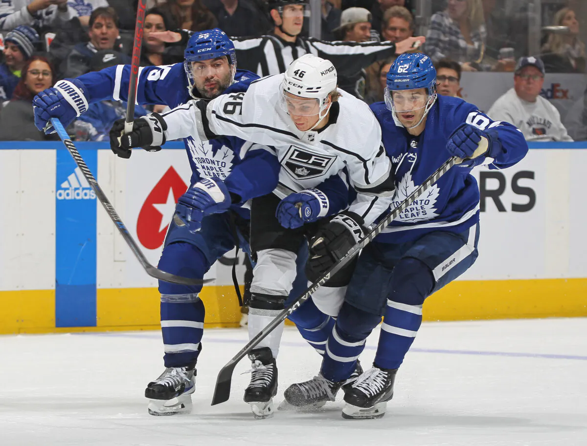 Blake Lizotte (46) of the Los Angeles Kings gets sandwiched by Mark Giordano (55) and Denis Malgin (62) of the Toronto Maple Leafs during an NHL game at Scotiabank Arena in Toronto, Ontario, Canada, on Dec. 8, 2022. (Claus Andersen/Getty Images)