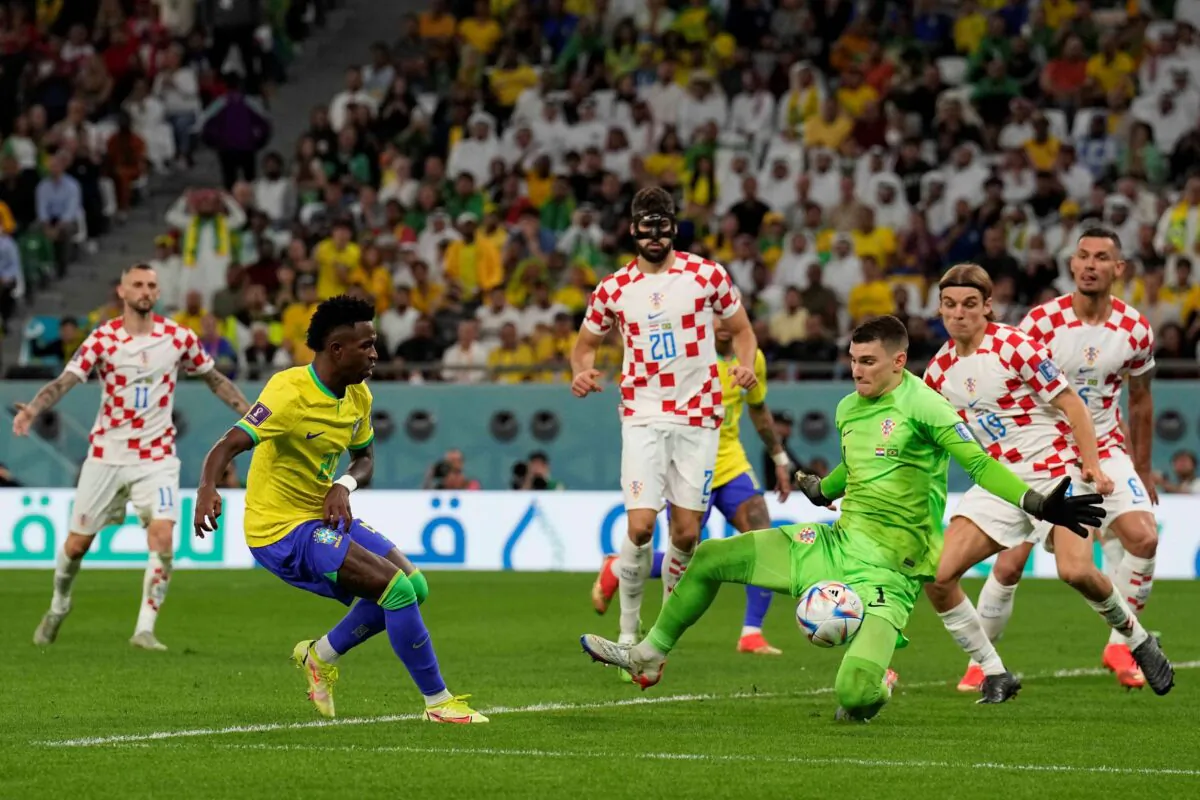 Brazil's Vinicius Junior (L) tries to score past Croatia's goalkeeper Dominik Livakovic who makes a save during the World Cup quarterfinal soccer match between Croatia and Brazil, at the Education City Stadium in Al Rayyan, Qatar, on Dec. 9, 2022. (Martin Meissner/AP)