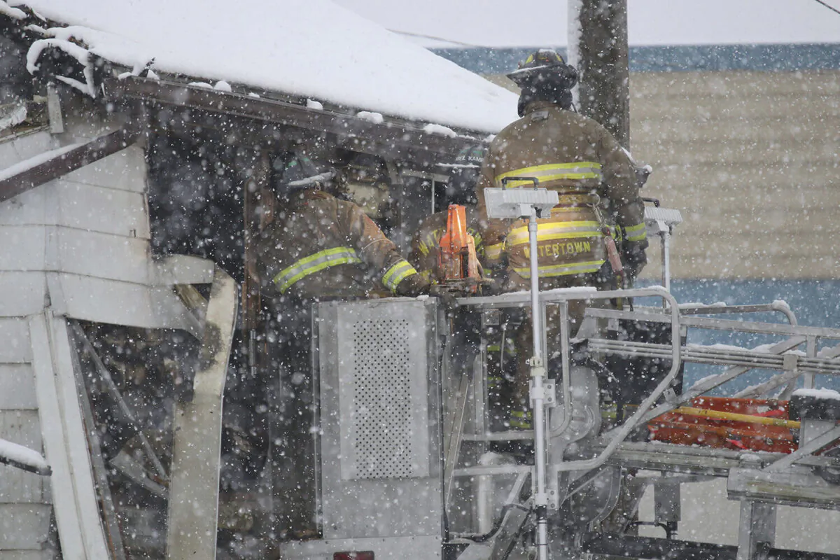 Using an aerial truck, Watertown firefighters help to investigate a house fire in Watertown, Wis., on Dec. 9, 2022. (Ed Zagorski/The Watertown Daily Times via AP)