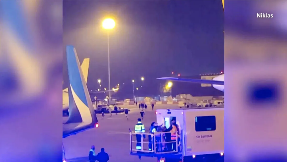 People run across the tarmac at Barcelona's El Prat airport in Spain on Dec. 7, 2022, as emergency services attended a plane. (Courtesy of Niklas via Reuters/Screenshot via NTD)