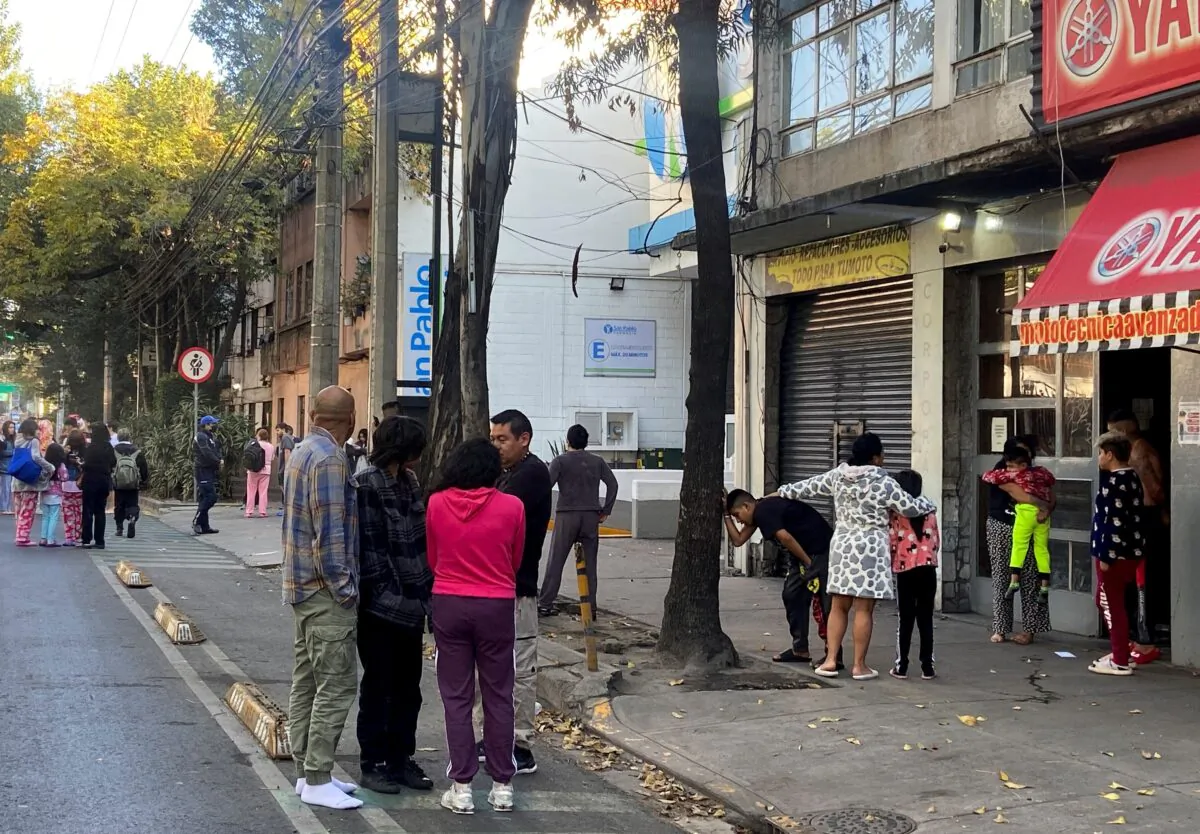 People stand outside after a tremor was felt in Mexico City, Mexico, on Dec. 11, 2022. (Raquel Cunha/Reuters)