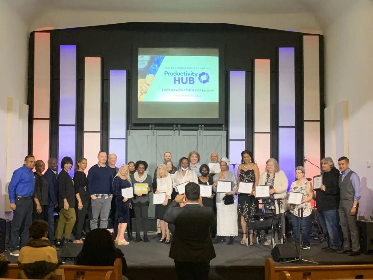Graduates and associates of the New Life Neighbourhood Centre Productivity HUB pose for a photo at the New Life Seventh-day Adventist Church in Oshawa, Ont., on Nov. 30, 2022. (Peter Wilson/The Epoch Times)