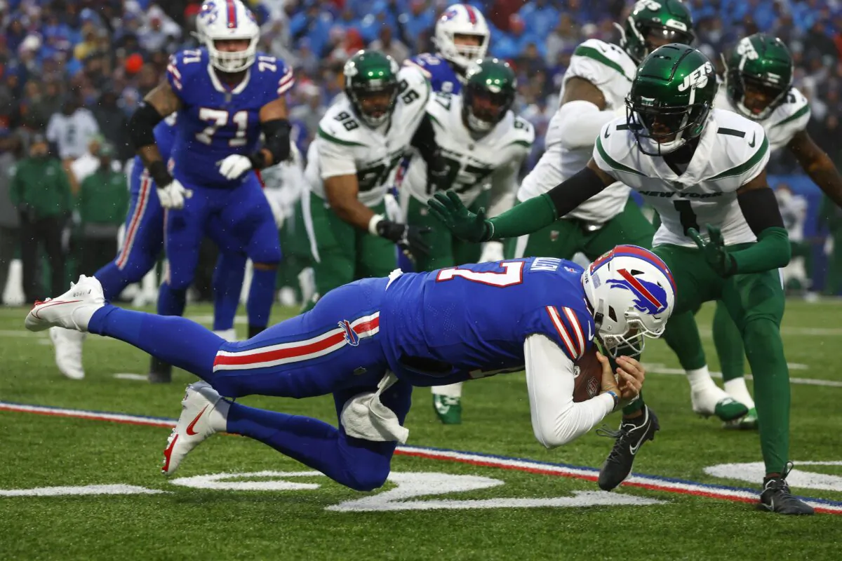 Buffalo Bills quarterback Josh Allen, front, lunges with the ball under pressure from New York Jets cornerback Sauce Gardner (1) during the first half of an NFL football game in Orchard Park, N.Y, on Dec. 11, 2022. (Jeffrey T. Barnes/AP Photo)