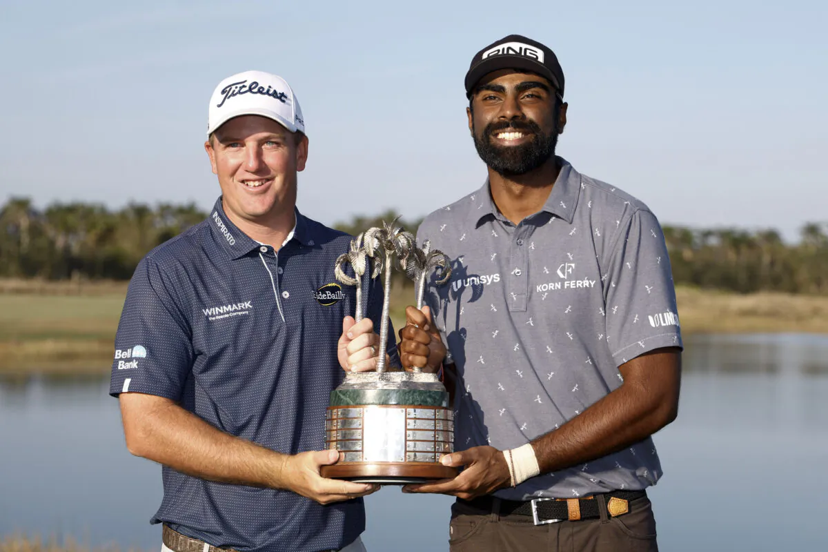Tom Hoge and Sahith Theegala of the United States pose with the trophy on the eighteenth green after winning the QBE Shootout at Tiburon Golf Club in Naples, Fla., on Dec. 11, 2022. (Douglas P. DeFelice/Getty Images)