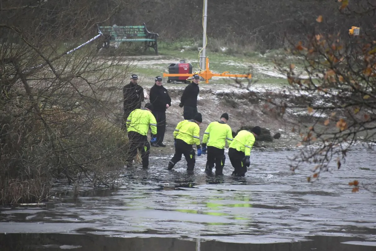 Police officers scour the lake, where three boys died, at Babbs Mill Park in Birmingham, England, on Dec. 12, 2022. (PA) 