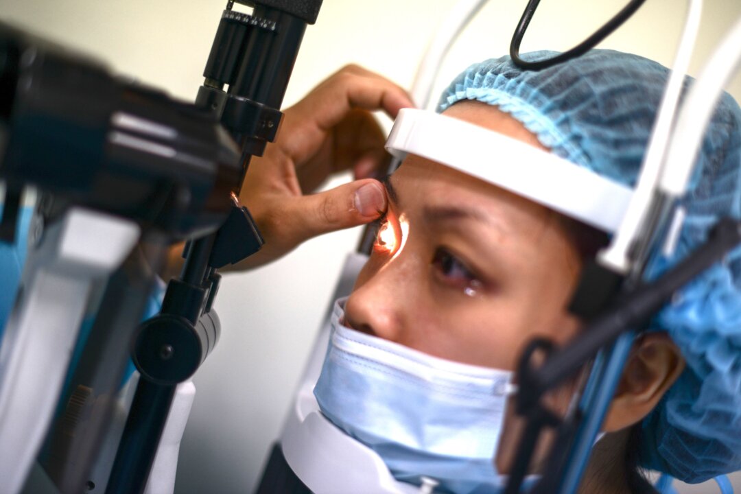 A staff member checks a patient after surgery at the LASIK Surgery Clinic in Singapore on Sept. 17, 2014. (Mohd Rasfan/AFP via Getty Images)