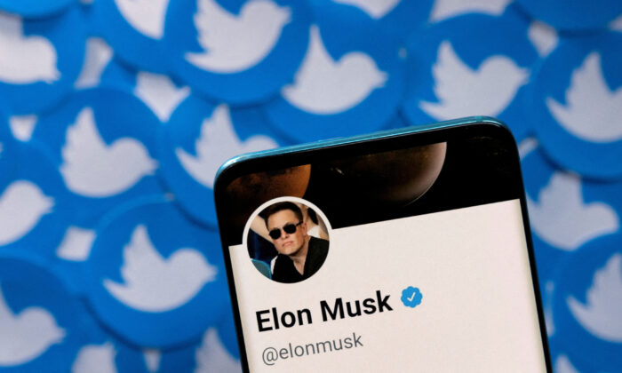 2022 年 4 月 28 日，伊隆·马斯克 (Elon Musk) 在智能手机上的 Twitter 个人资料印在印刷的 Twitter 徽标上。（Dado Ruvic/Illustration/Reuters）