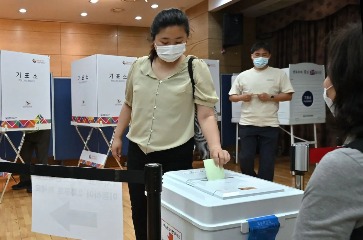 A woman casts her vote for nationwide local elections to elect mayors, governors, local council members and regional education chiefs at a polling station in Seoul on June 1, 2022. (Jung Yeon-je/AFP via Getty Images)