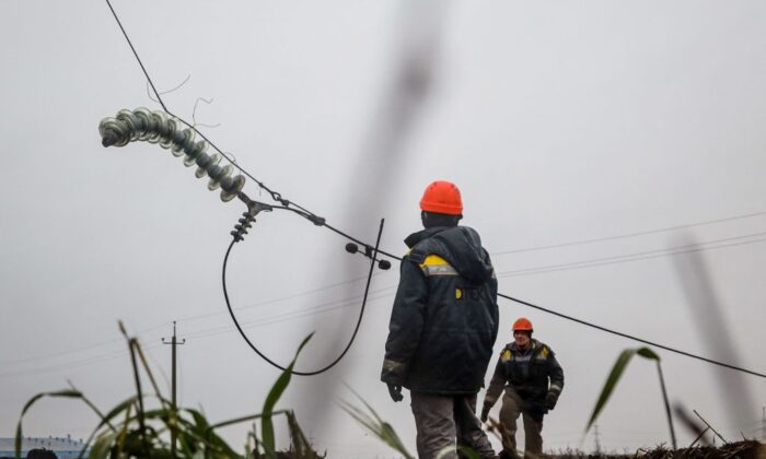 2022 年 12 月 7 日，在俄罗斯入侵乌克兰期间，工人在敖德萨附近修理最近因导弹袭击而切断的高压电线。  （照片由 Oleksandr Gimanov/法新社通过 Getty Images 拍摄）