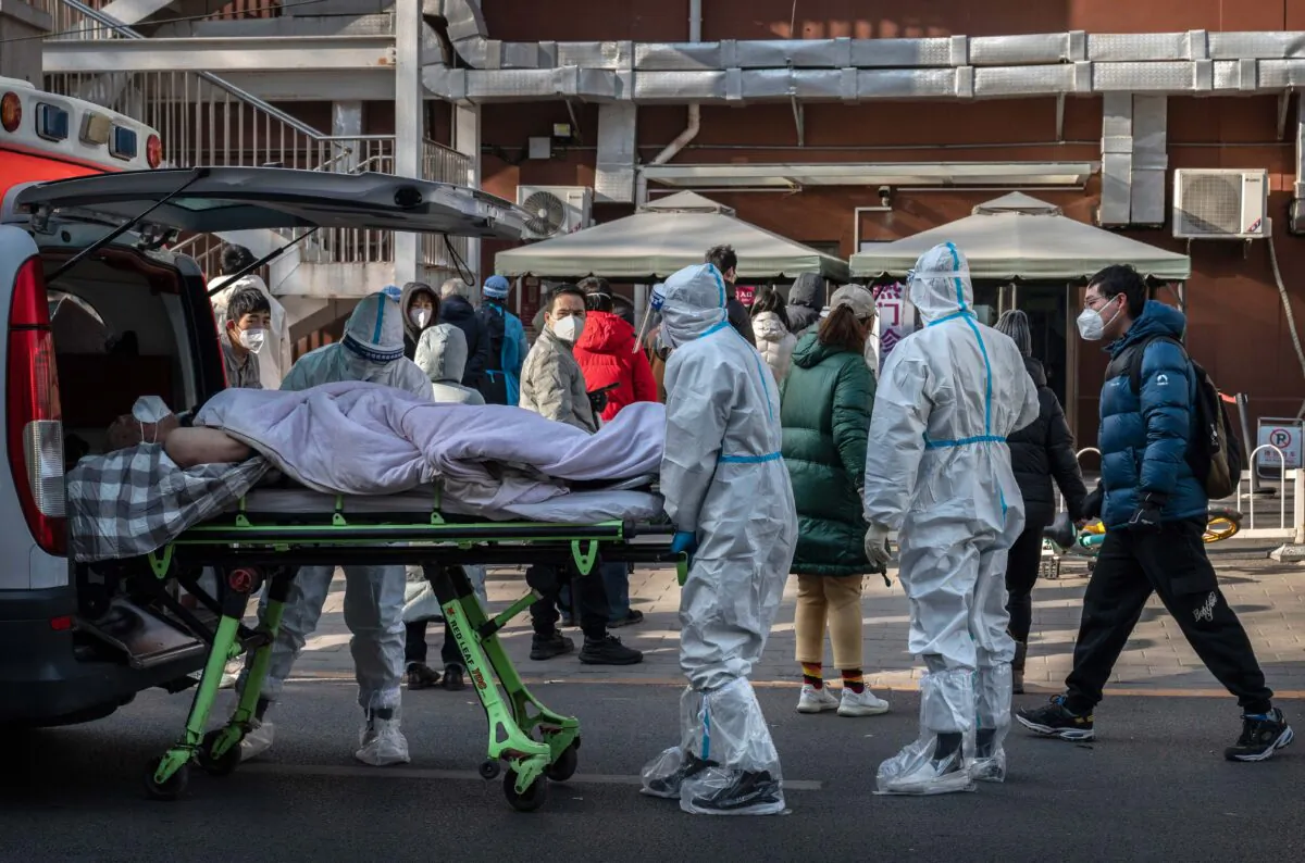 Medical workers arrive with a patient at a fever clinic in Beijing, China, on Dec. 9, 2022. (Kevin Frayer/Getty Images)
