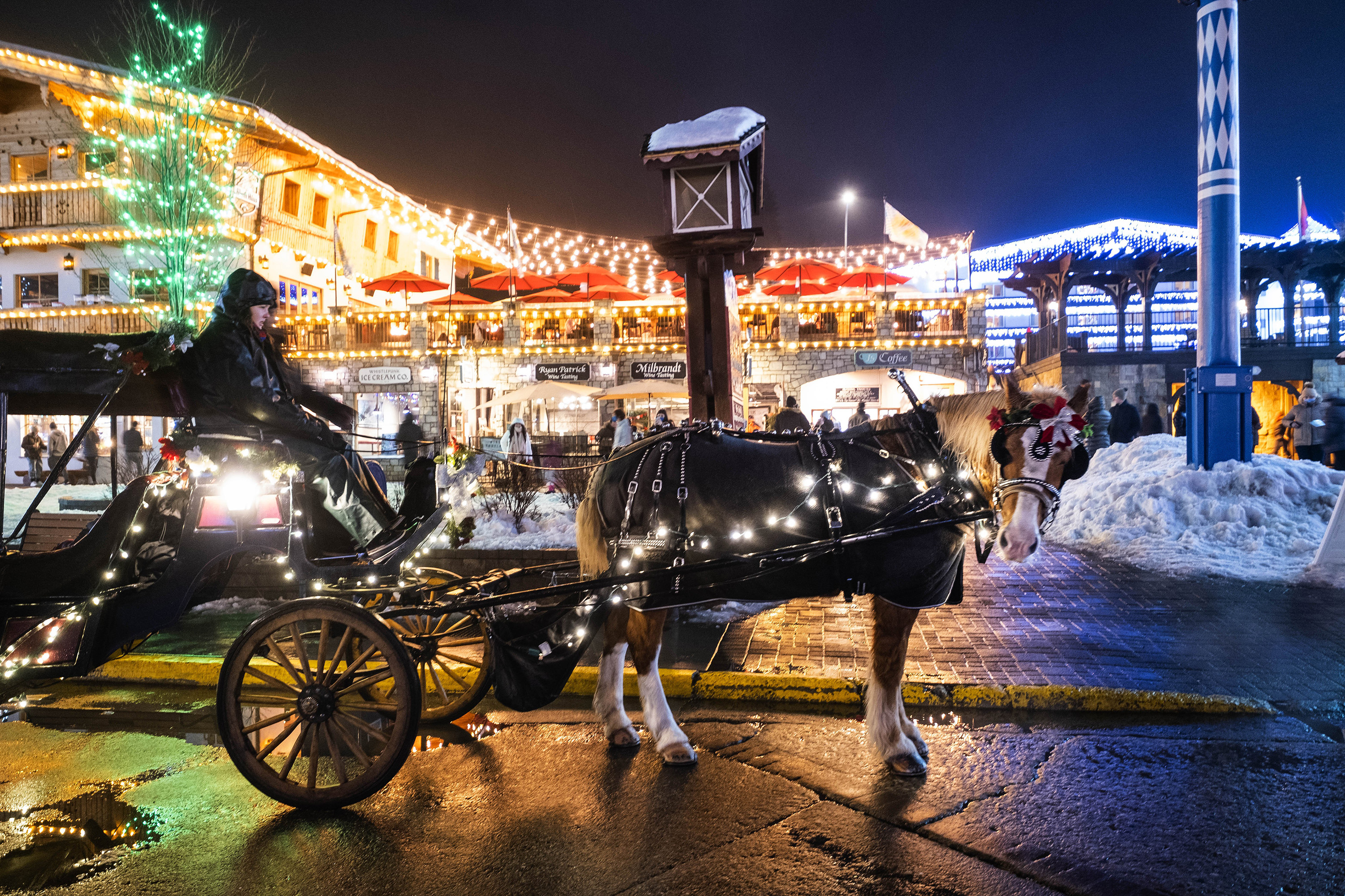 A horse and carriage is lit up in downtown Leavenworth, offering rides through the city's streets .