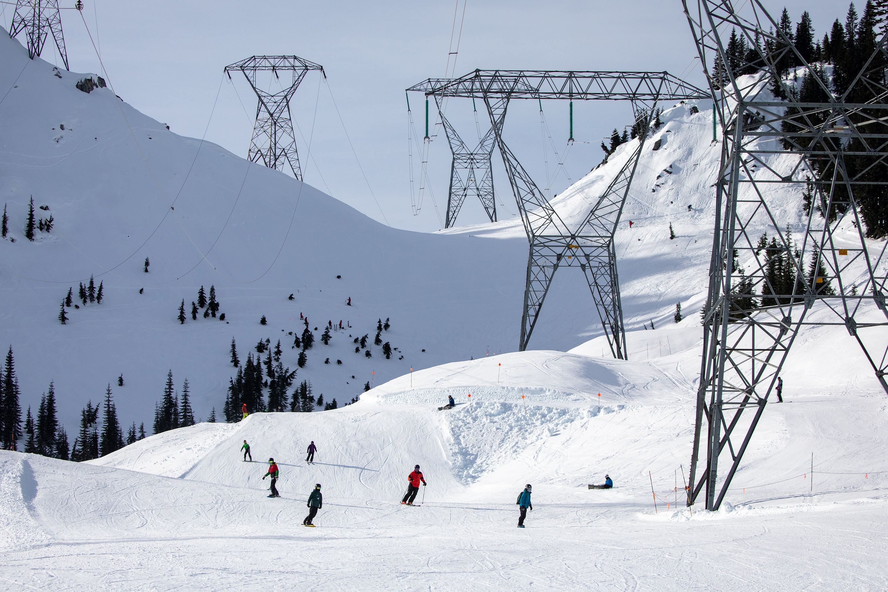 Skiers and snowboarders come down Gemini under the power lines on the back side of the mountain Friday, Jan. 28, 2022, at Stevens Pass, Washington.