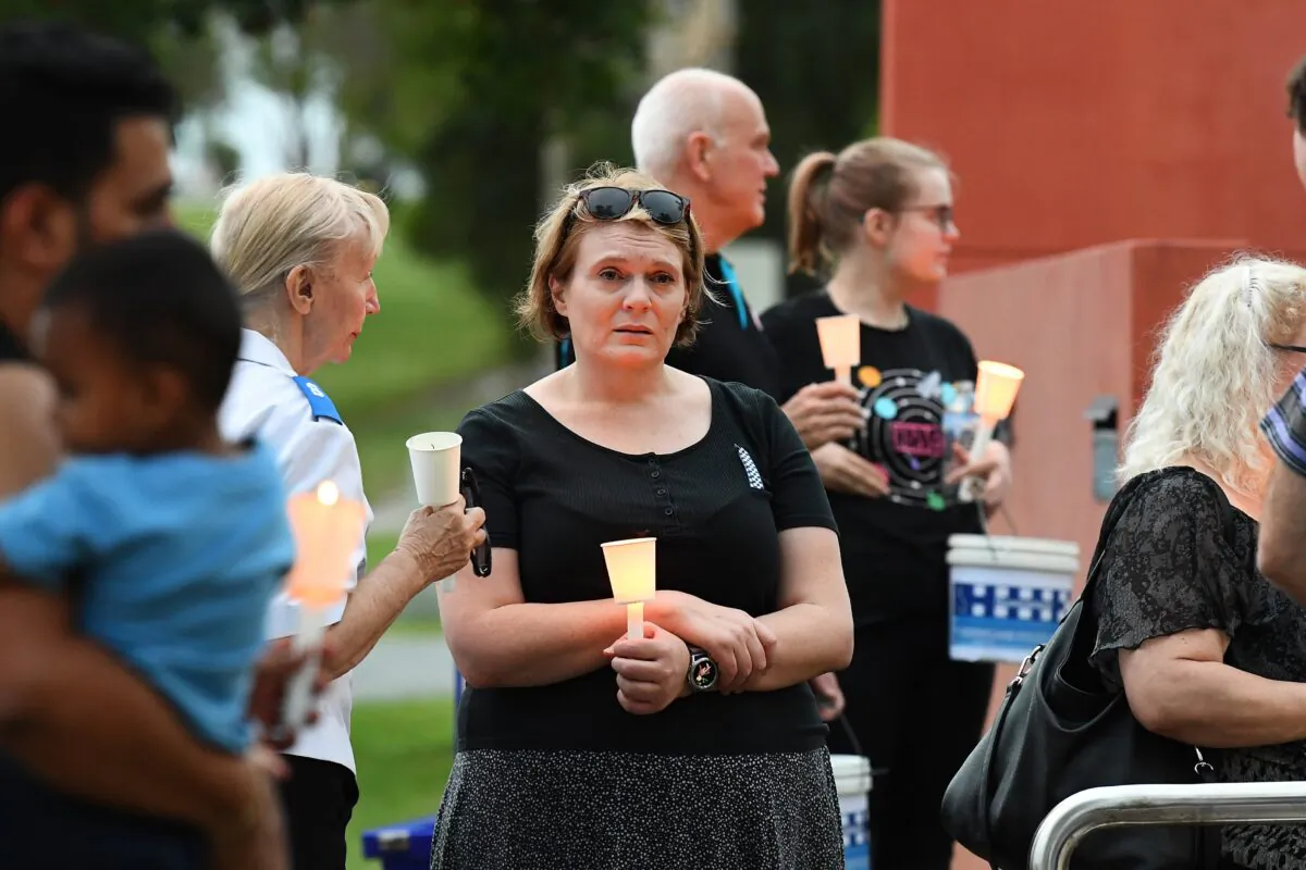 Members of the local community take part in a vigil at Calamvale police station, Calamvale, south of Brisbane, Queensland in Australia on Dec. 13, 2022. Constables Matthew Arnold, 26, and Rachel McCrow, 29, died in an ambush and siege at a remote Queensland property. (AAP Image/Jono Searle)