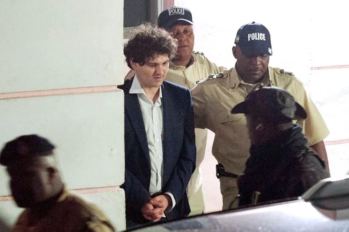 FTX founder Sam Bankman-Fried (2nd L) is led away handcuffed by officers of the Royal Bahamas Police Force in Nassau, Bahamas, on Dec. 13, 2022. (Mario Duncanson/AFP via Getty Images)