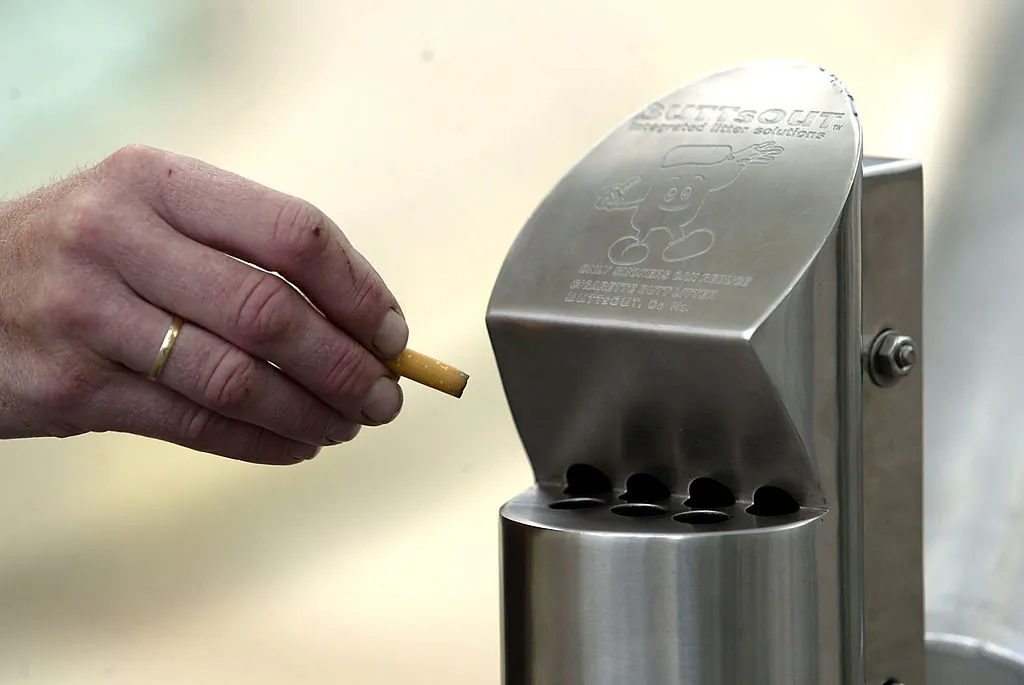 A person shows off the new rubbish bins for smokers as part of the ACC plan to keep cigarette butts off the streets, in Auckland, N.Z., on Dec. 10 2004. (Michael Bradley/Getty Images)
