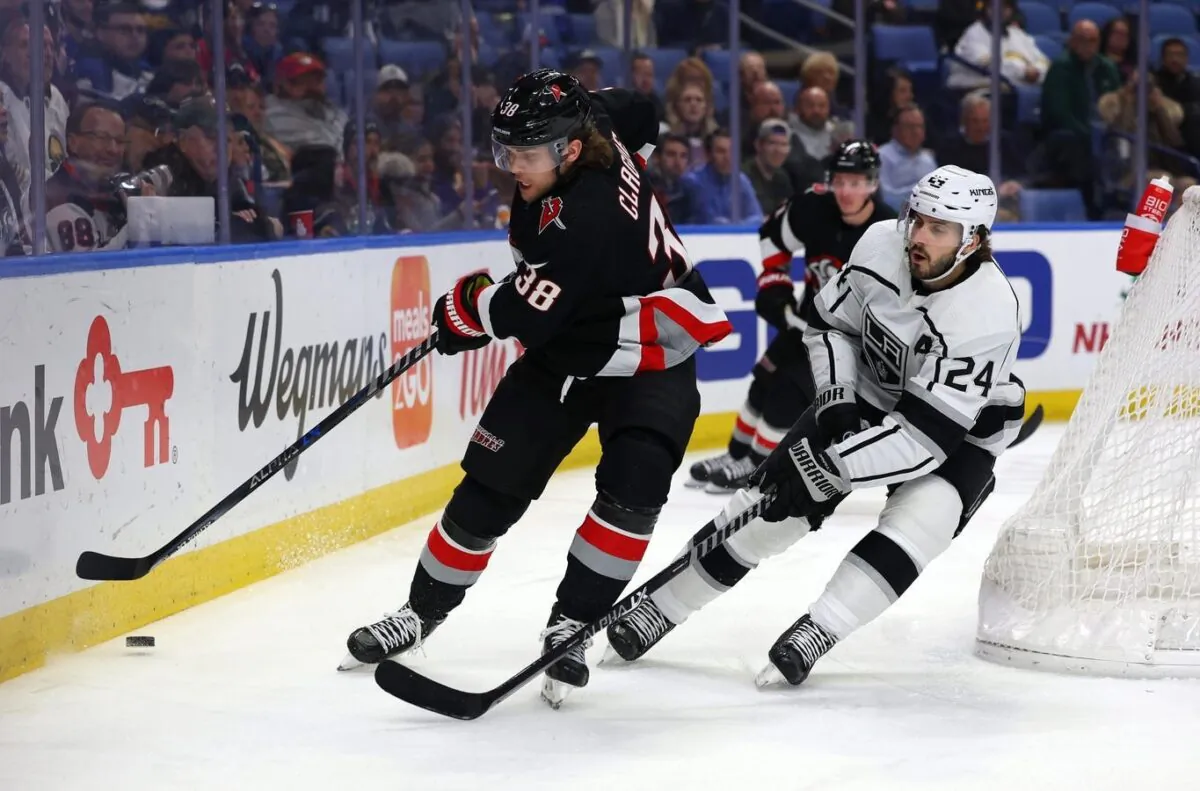 Buffalo Sabres defenseman Kale Clague (38) clears the puck behind the net as Los Angeles Kings center Phillip Danault (24) defends during the first period at KeyBank Center in Buffalo, N.Y., on Dec. 13, 2022. (Timothy T. Ludwig/USA TODAY Sports via Field Level Media)