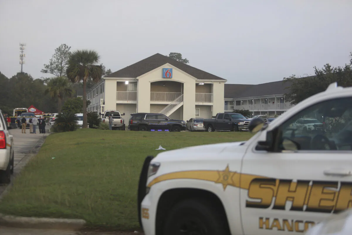 Law enforcement officials investigate the Motel 6 where two Bay St. Louis police officers were killed in a shooting on Dec. 14, 2022. (Justin Mitchell/The Sun Herald, via AP)