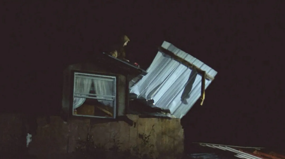 An emergency worker moves debris on top of damaged house early in Caddo Parish, La., on Dec. 14, 2022. (KSLA via AP)