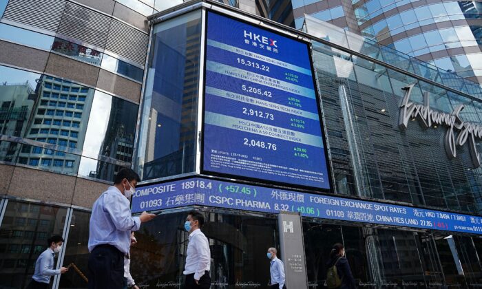 2022 年 10 月 25 日，中国香港中区，人们走过显示恒生股票指数的屏幕。（Lam Yik/路透社）