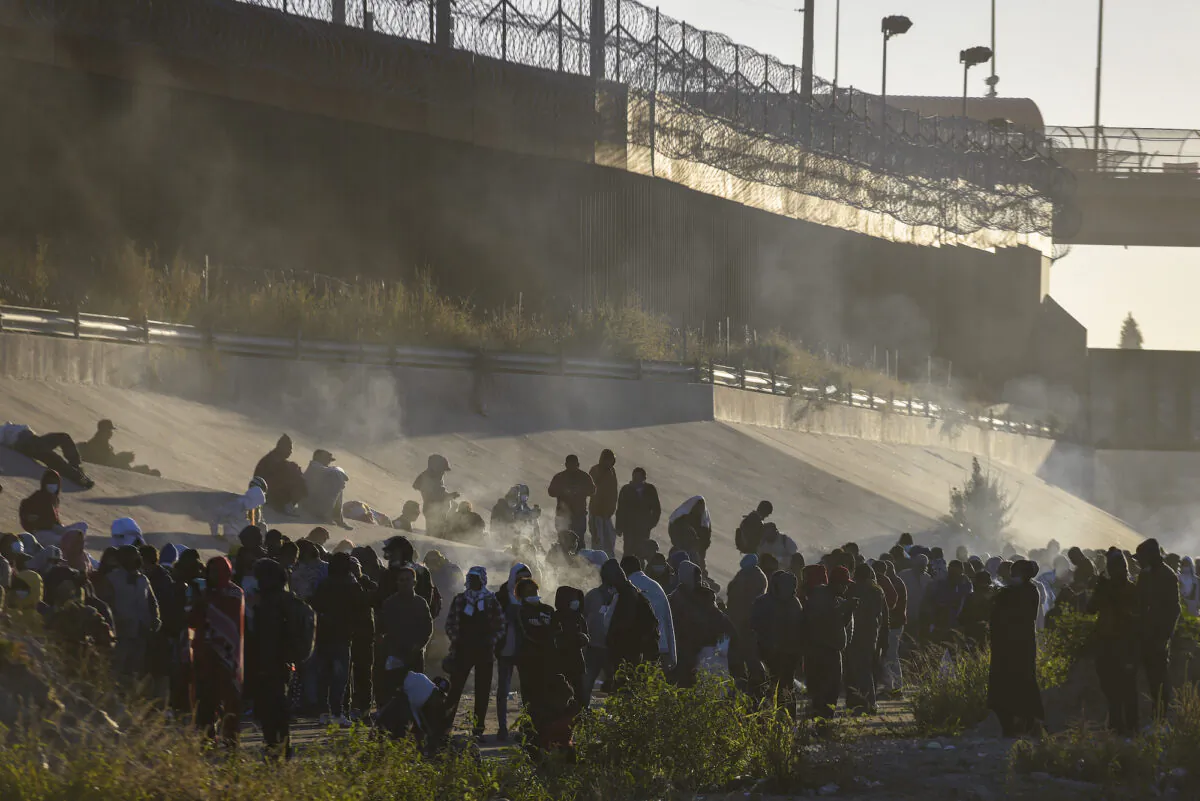 Smoke rises from small fires as people wait to cross the Mexico-U.S. border from Ciudad Juarez, Mexico, on Dec. 12, 2022. (AP Photo/Christian Chavez)
