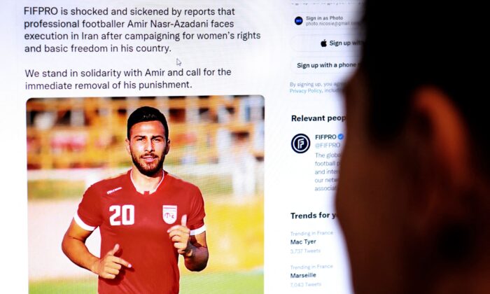 2022 年 12 月 13 日，塞浦路斯首都尼科西亚的一名人士查看了国际职业足球运动员联合会 (FIFPRO) 发布的一条推文，内容涉及伊朗足球运动员阿米尔·纳斯尔-阿扎达尼 (Amir Nasr-Azadani) 因抗议活动而被判处死刑的风险，这些抗议活动动摇了三个月的国家。  （法新社通过盖蒂图片社）