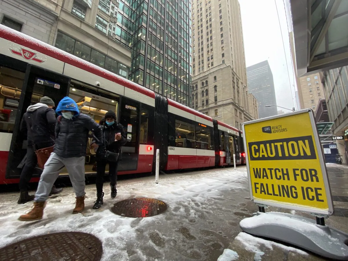 Passengers step off a streetcar during a snowy day in Toronto on Nov. 15, 2022. (The Canadian Press/Graeme Roy)