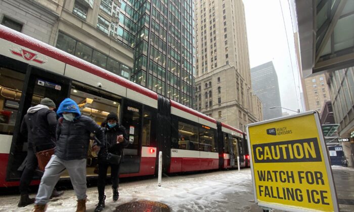 2022 年 11 月 15 日，在多伦多的一个下雪天，乘客从​​有轨电车上下来。（加拿大新闻社/Graeme Roy）