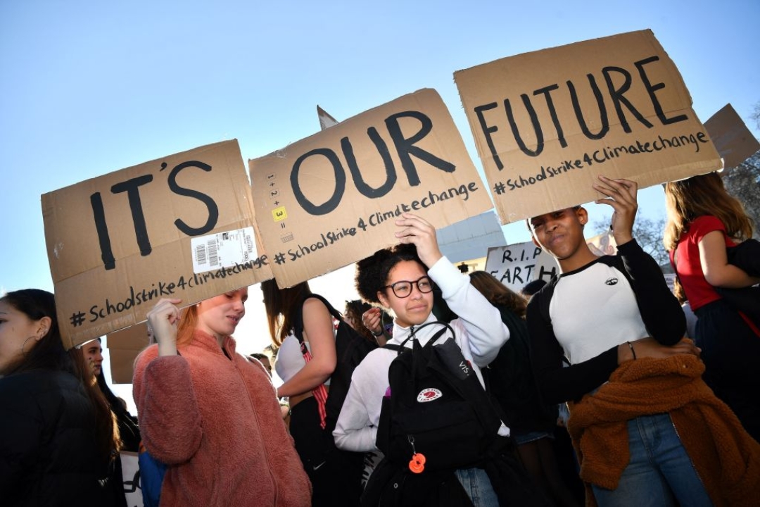 Young demonstrators hold placards as they attend a climate change protest opposite the Houses of Parliament in central London on Feb. 15, 2019. (Ben Stansall/AFP via Getty Images)
