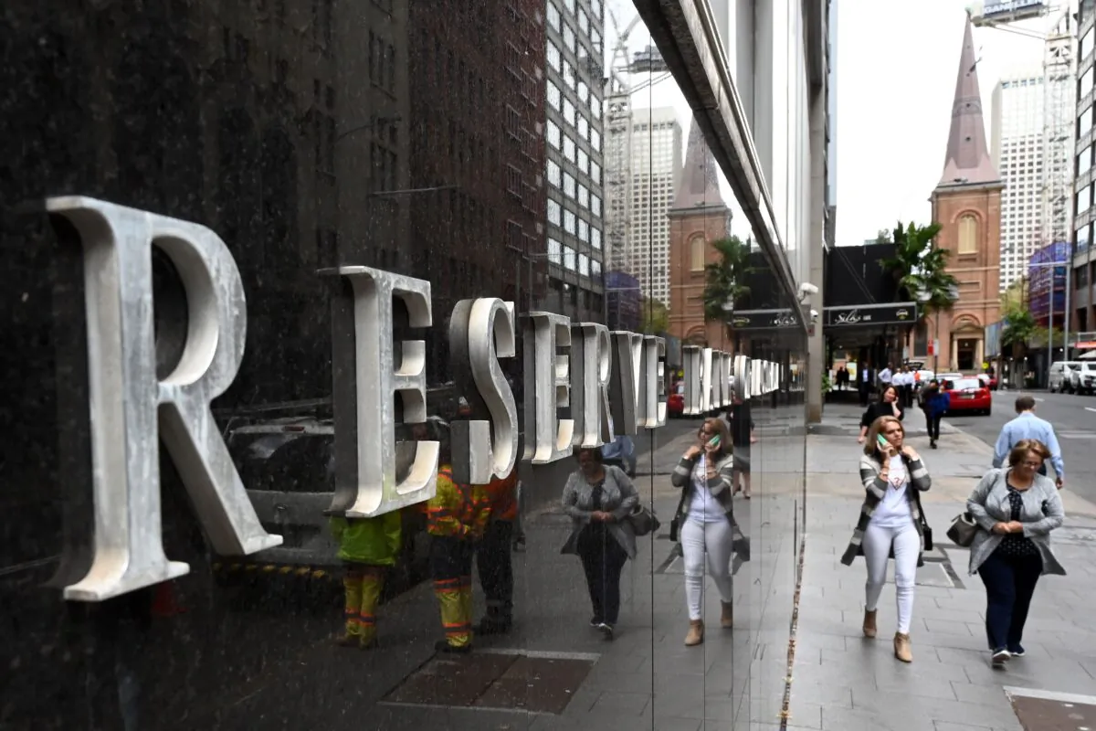 Pedestrians are reflected in the wall of the Reserve Bank of Australia in Sydney, Australia, on April 2, 2019. (Saeed Khan/AFP via Getty Images)