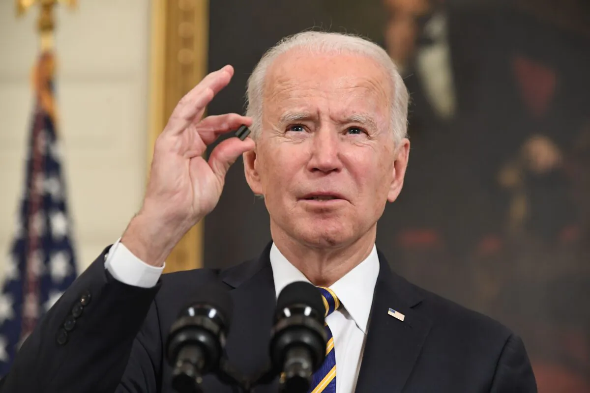 President Joe Biden holds a microchip as he speaks before signing an executive order on securing critical supply chains, in the State Dining Room of the White House in Washington on Feb. 24, 2021. (Saul Loeb/AFP via Getty Images)