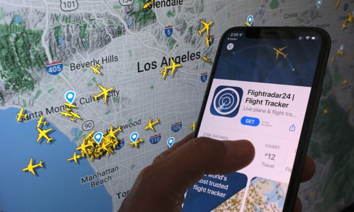 2022 年 8 月 5 日，在屏幕前的智能手机上可以看到 Flightradar24 应用程序，显示该应用程序跟踪的飞机在加利福尼亚州洛杉矶地区的实时位置。（Chris Delmas/法新社来自 Getty Images）