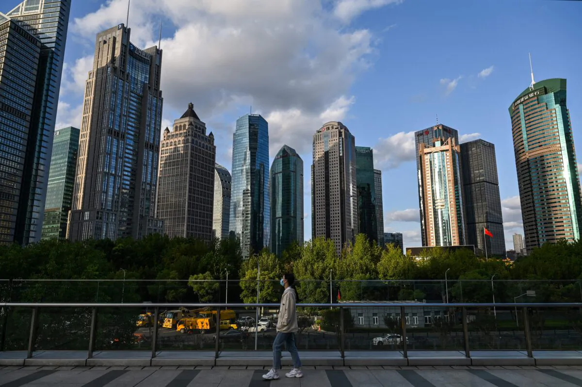 A woman walks on a bridge in the financial district of Lujiazui in Shanghai, China, on Oct. 17, 2022. (Hector Retamal/AFP via Getty Images)