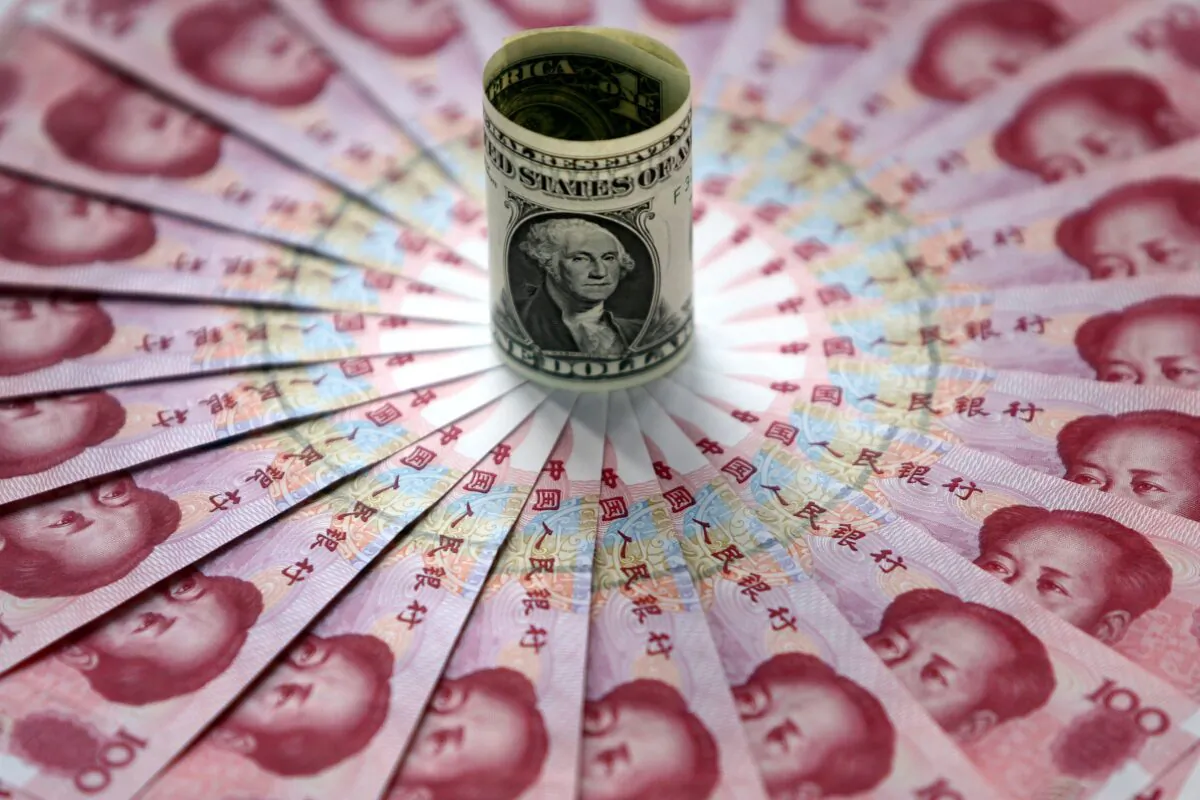 One dollar and 100 yuan notes are on display at a bank on May 15, 2006 in Beijing, China. China's official exchange rate rose today to 7.9982 yuan per U.S. dollar, its highest level since a revaluation in last July, the government said. (China Photos/Getty Images)