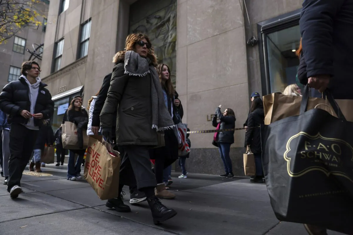 Shoppers carry bags down Fifth Avenue in New York on Nov. 25, 2022. (Julia Nikhinson/AP Photo)