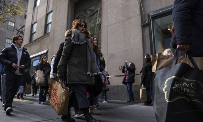 2022 年 11 月 25 日，购物者提着袋子走在纽约第五大道。（Julia Nikhinson/美联社照片）