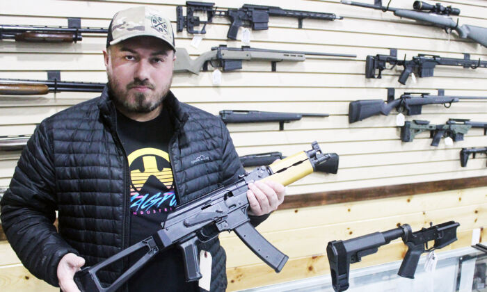 俄克拉荷马州杜兰特 Barrett Outdoors 的老板贾斯汀·巴雷特 (Justin Barrett) 展示了一把带有手枪稳定支架的 AK 手枪。 他旁边的柜台上有一个类似的 AR15 手枪支架。  （迈克尔·克莱门茨/媒体）