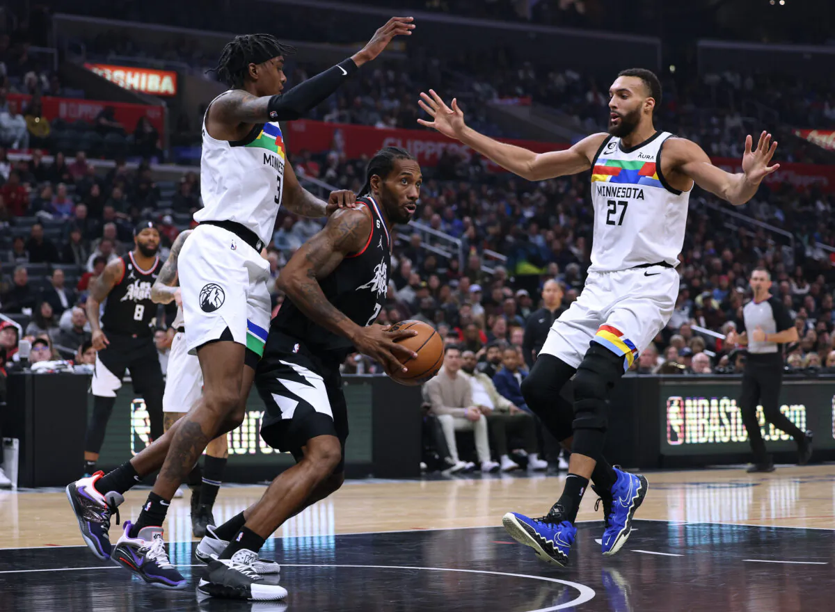 Kawhi Leonard (2) of the LA Clippers keeps his dribble in front of Jaden McDaniels (3) and Rudy Gobert (27) of the Minnesota Timberwolves during the first half at Crypto.com Arena in Los Angeles, on Dec. 14, 2022. (Harry How/Getty Images) 