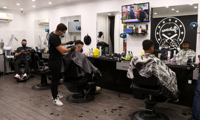 2021 年 10 月 11 日，人们看到 Fadezone 理发店的工作人员在澳大利亚悉尼理发。（Mark Kolbe/Getty Images）