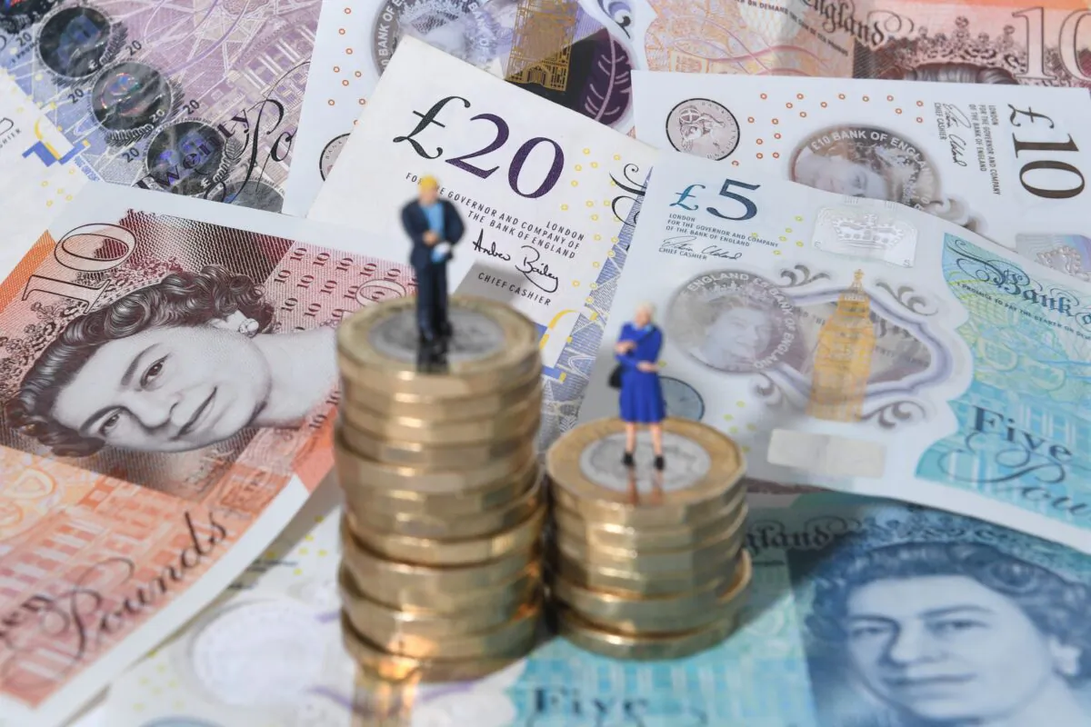 Models of a man and woman stand on a pile of British coins and bank notes, in this file photo dated Sept. 11, 2018. (Joe Giddens/PA Media)