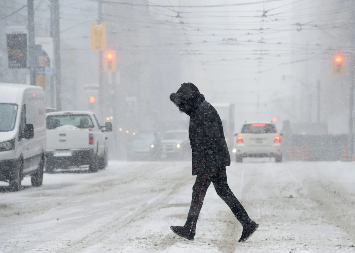 A man crosses a downtown street during a winter storm in Toronto on Feb. 27, 2019. (Frank Gunn/The Canadian Press)