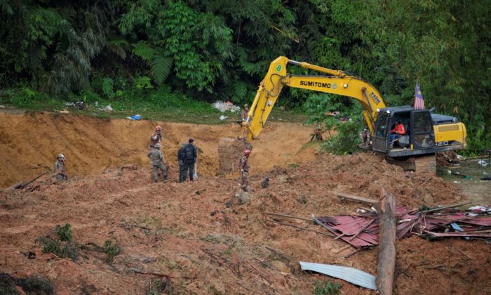 2022 年 12 月 17 日，救援队使用挖掘机继续寻找在马来西亚巴当卡里陷入山体滑坡的受害者。（Vincent Thian/美联社照片）
