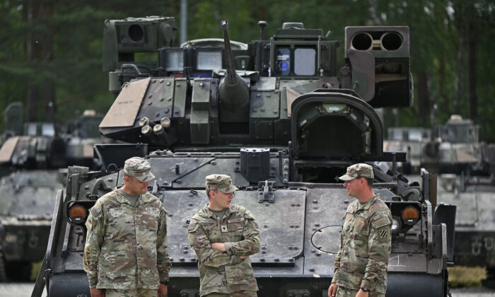 2022 年 7 月 13 日，美国陆军第一突击旅的士兵站在德国格拉芬沃尔附近的格拉芬沃尔训练场的坦克前。（Lennart Preiss/Getty Images）