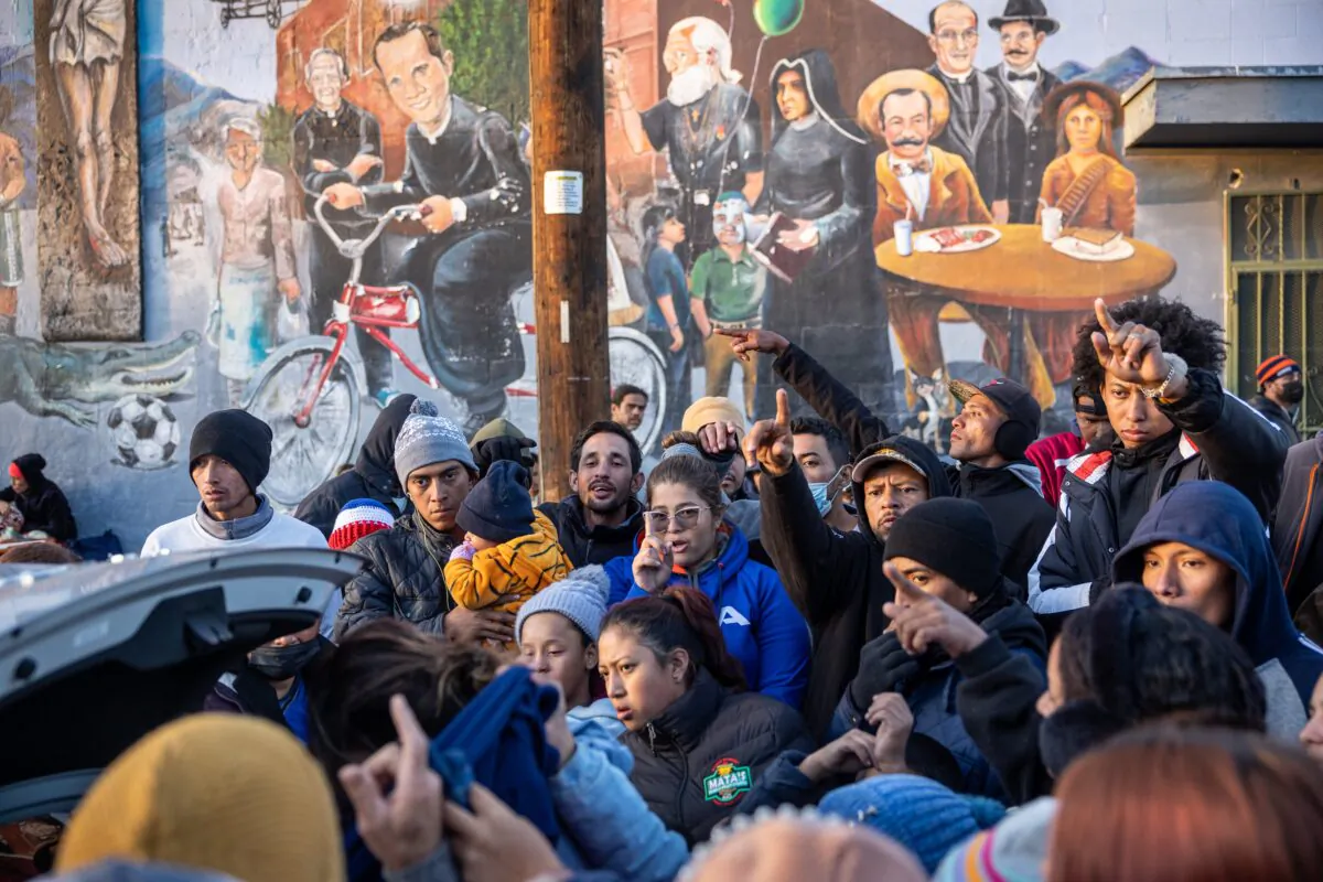 Illegal immigrants receive donated clothing outside a shelter at the Sacred Heart Church in El Paso, Texas, on Dec. 17, 2022. (John Moore/Getty Images)