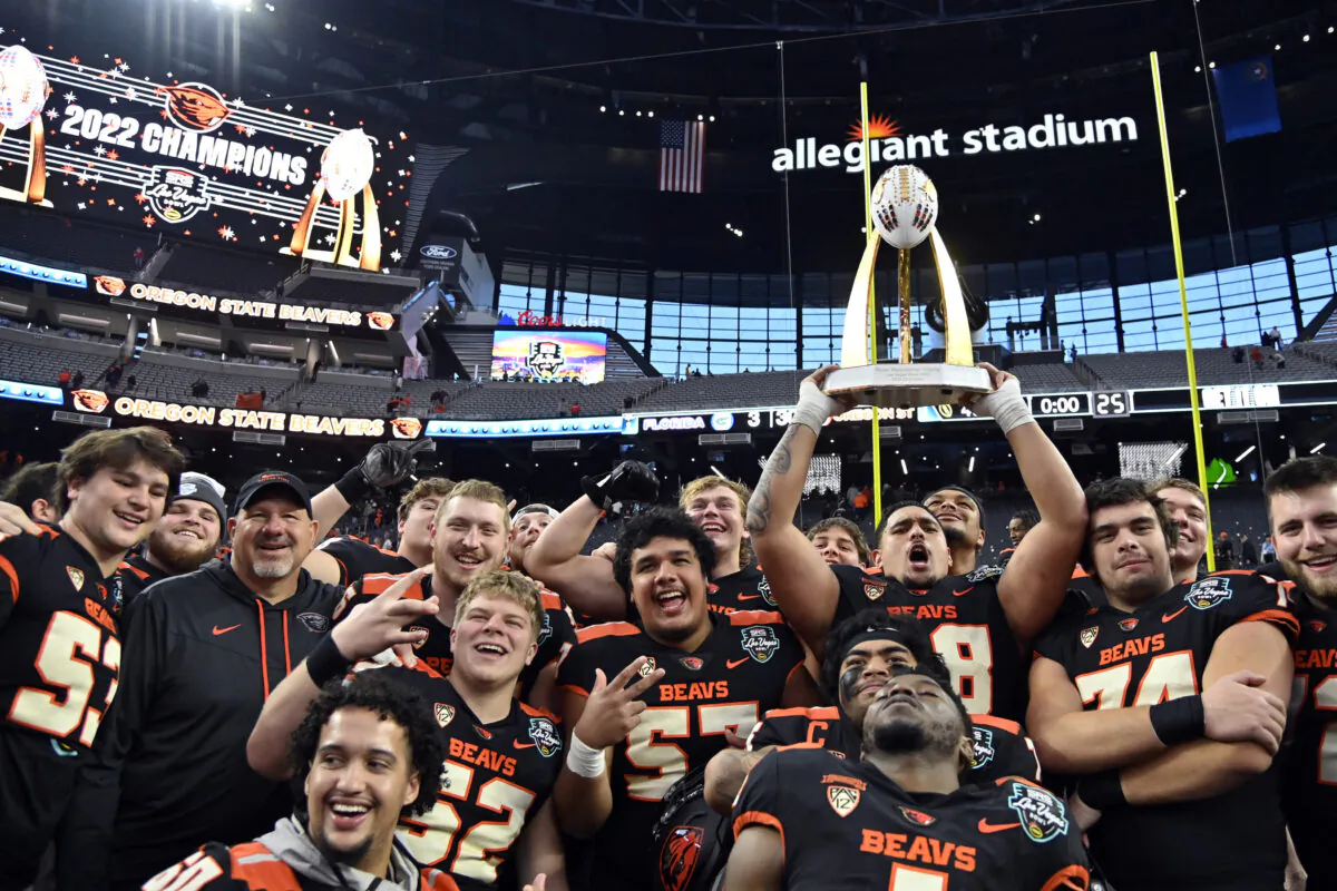 Heneli Bloomfield (58) of the Oregon State Beavers hoists up the championship trophy as he stands with teammates after they defeated the Florida Gators in the SRS Distribution Las Vegas Bowl at Allegiant Stadium in Las Vegas on December 17, 2022. (David Becker/Getty Images)