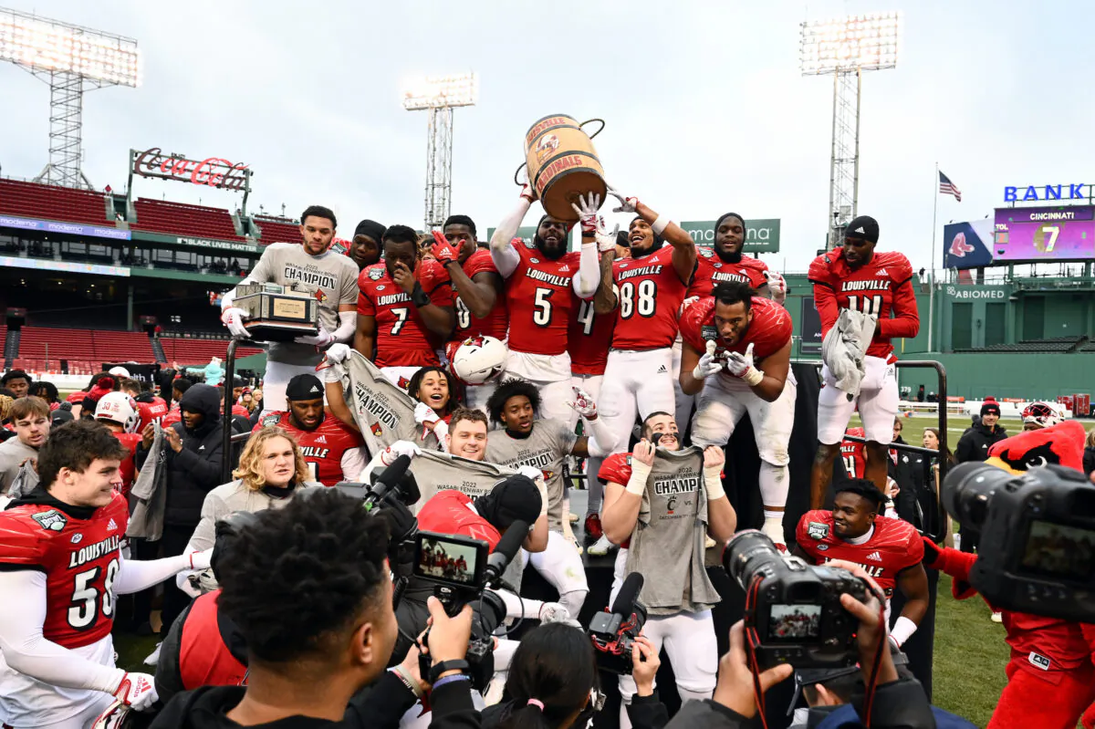 The Louisville Cardinals celebrate with the Wasabi Bowl and Keg of Nails trophies after beating the Cincinnati Bearcats at Fenway Park in Boston on Dec. 17, 2022. (Brian Fluharty/Getty Images)