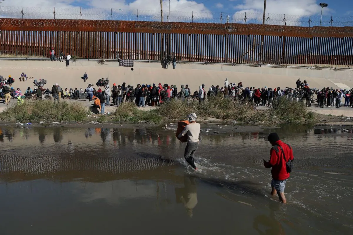 Illegal immigrants walk across the Rio Grande to surrender to U.S. Border Patrol agents in El Paso, Texas, as seen from Ciudad Juarez, Chihuahua state, Mexico, on Dec. 13, 2022. (Herika Martine/AFP via Getty Images)